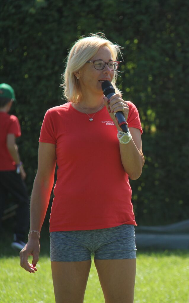 Camp-Leiterin mit Mikrofon vor der Gruppe